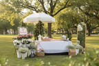 BloomDrop Flower Bar setup with white fringed umbrella, pink and white flowers, gold mirror and baby's breath baskets